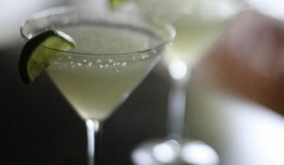 Margarita in a martini glass with salt and a lime.