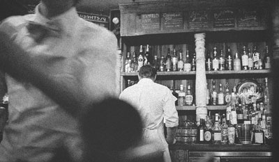 Bartender behind the counter making a cocktail.