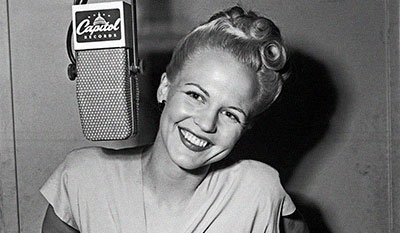 Woman smiling next to a microphone.